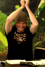 a man with a beanie on crumples over the table laughing at a joke